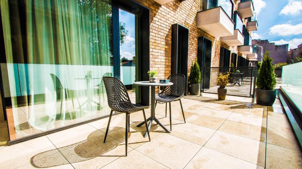 a patio with three chairs and a table in front of a building at Central Carol 1 in Bucharest