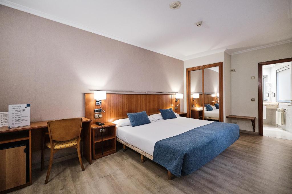 A bed or beds in a room at Hotel Ciudad de Compostela
