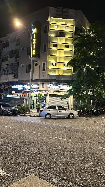 a car parked on the side of a street at night at Mizie Hotel Kuala Lumpur in Kuala Lumpur