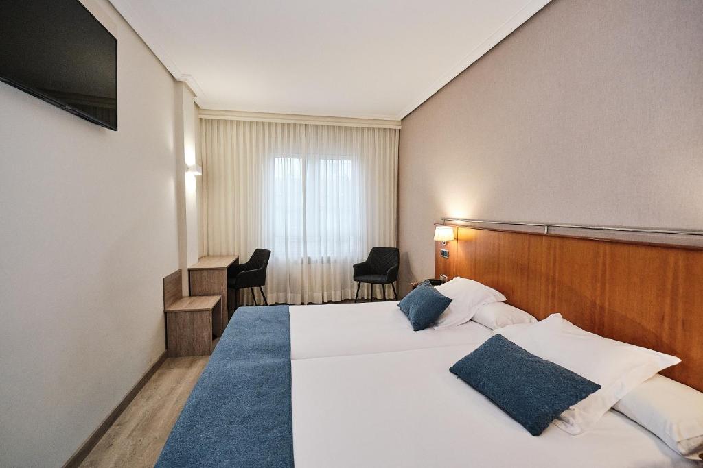 A bed or beds in a room at Hotel Ciudad de Compostela