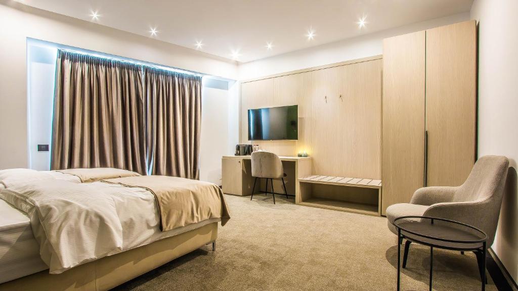 Schlafzimmer mit einem Bett, einem Schreibtisch und einem Stuhl in der Unterkunft Central Carol 1 in Bukarest