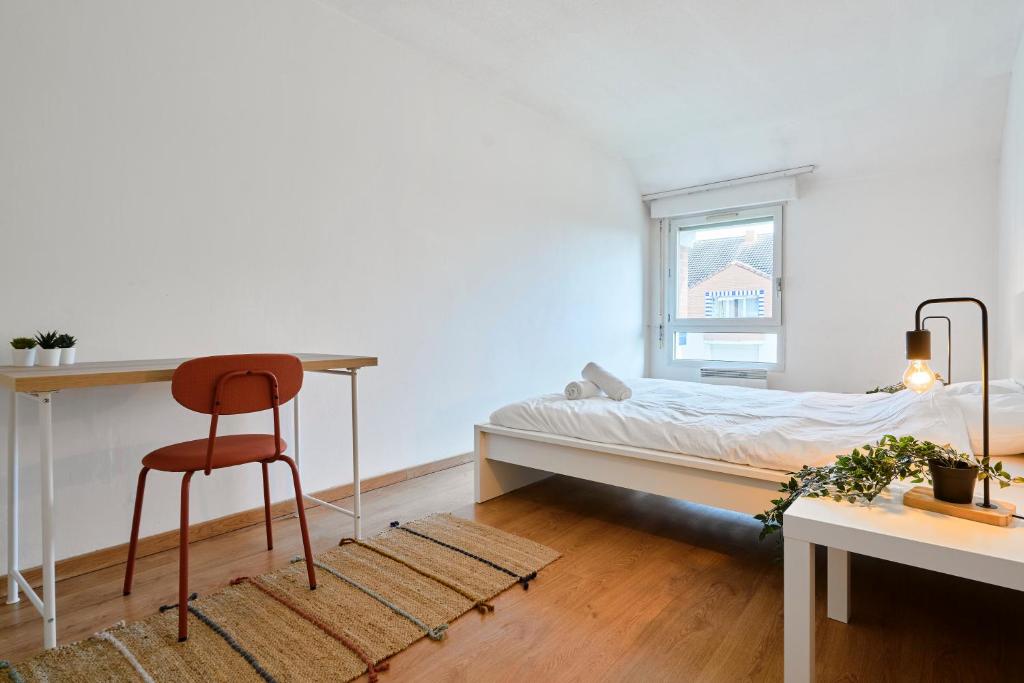 une chambre avec un lit, un bureau et une chaise dans l'établissement T2 confortable à Lille Saint Maurice Pellevoisin, à Lille