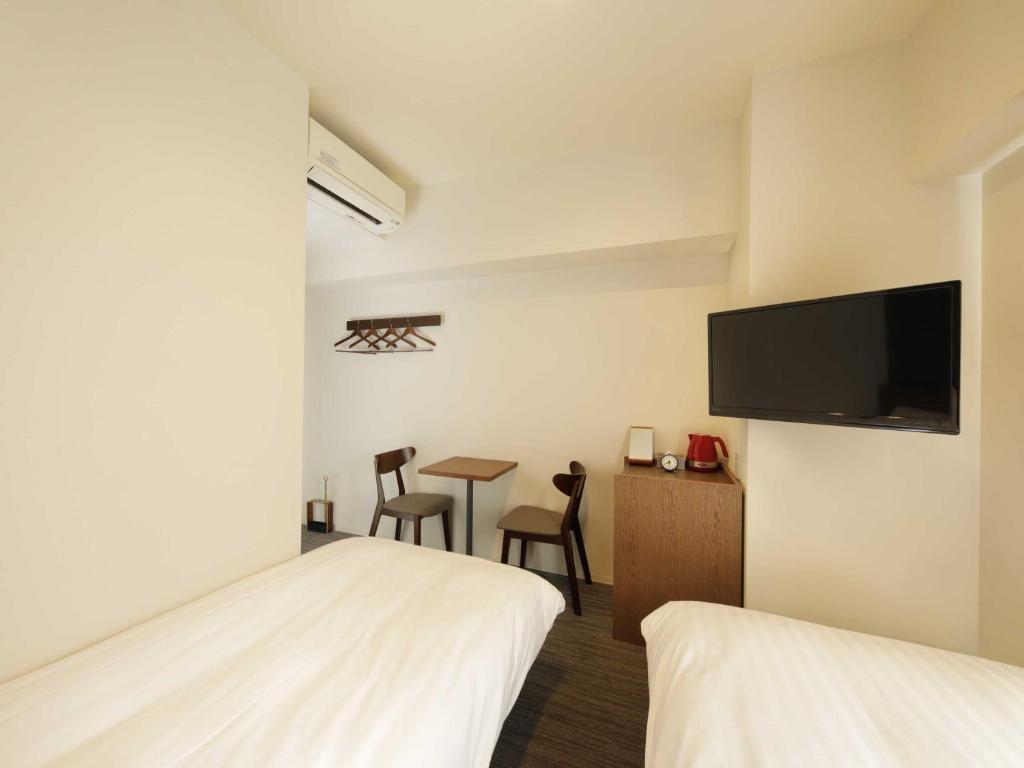 Postel nebo postele na pokoji v ubytování Smart Place Inn Kyoto Nijojo-mae Station