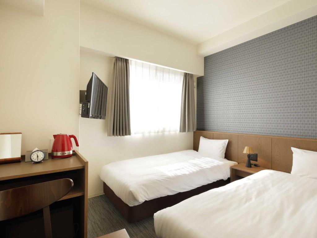 Postel nebo postele na pokoji v ubytování Smart Place Inn Kyoto Nijojo-mae Station