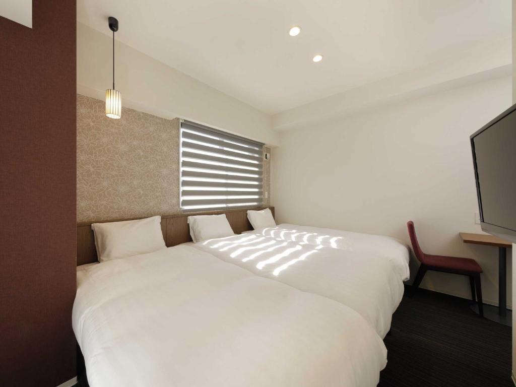 Postel nebo postele na pokoji v ubytování Smart Place Inn Kyoto Nijojo-mae Station