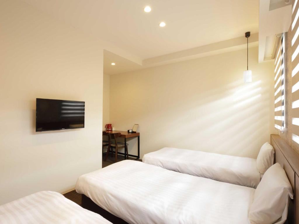 Postel nebo postele na pokoji v ubytování Smart Place Inn Kyoto Nijojo-mae Station