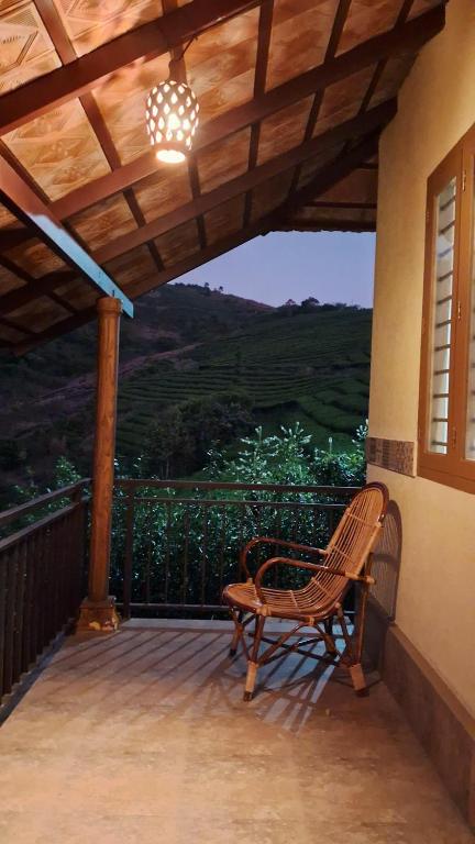 a wooden bench sitting on a porch with a view at Heritage Farm Kerala in Idukki