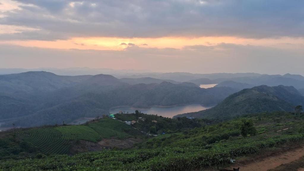 a view of a valley from a hill with mountains at Heritage Farm Kerala in Idukki