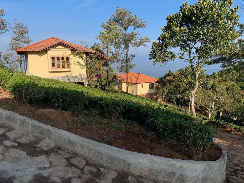 a house sitting on top of a grassy hill at Heritage Farm Kerala in Idukki
