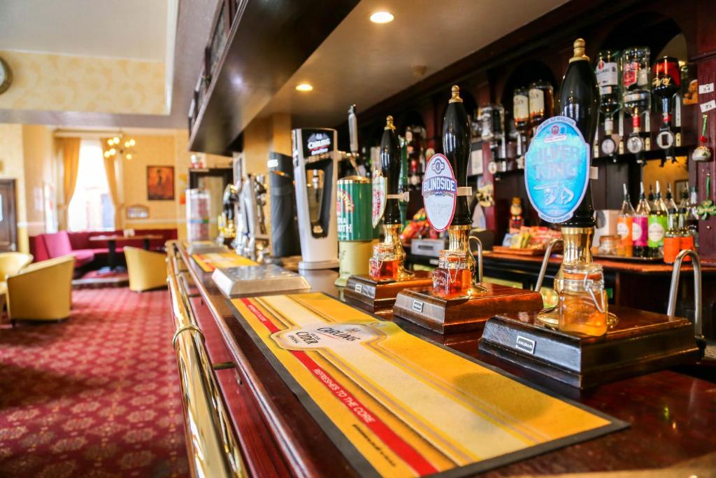 een bar met flessen alcohol op de toonbank bij The Station Hotel in Worksop