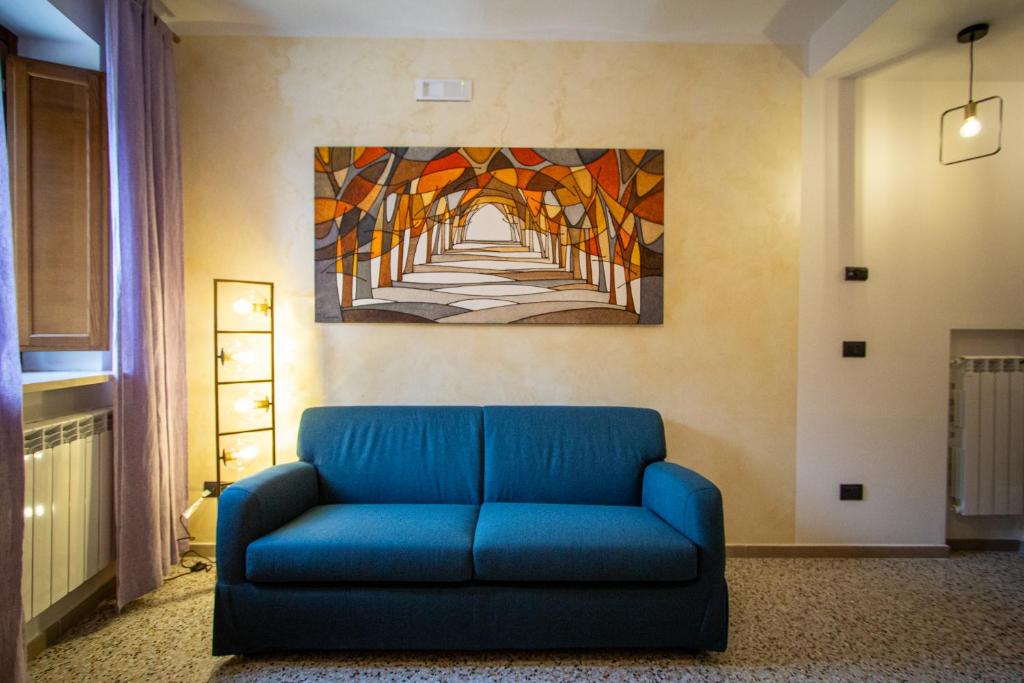 a blue couch in a room with a painting on the wall at Casa nel Borgo -Affitti Brevi Italia in LʼAquila