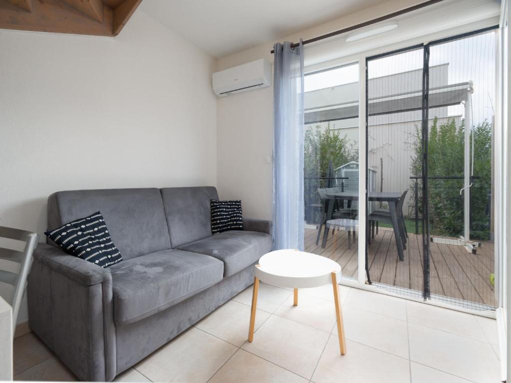 un salon avec un canapé et une table dans l'établissement La Dune 65 - Villa 3P6, à Sérignan