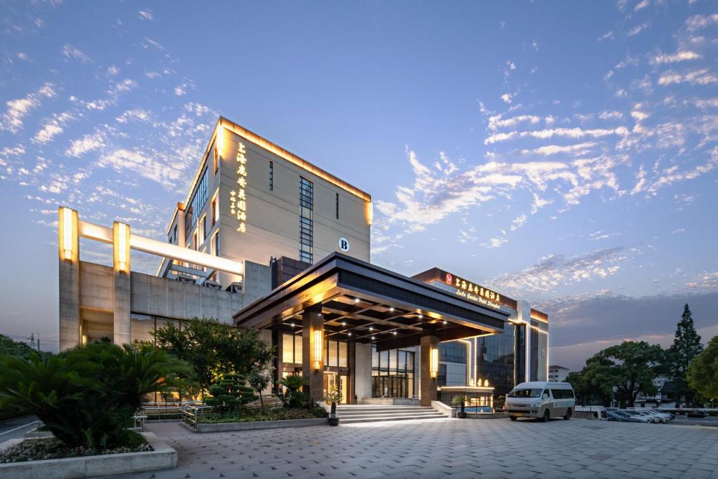 上海市にあるShangHai LuAn Garden Hotelの建物の前に車が駐車されている