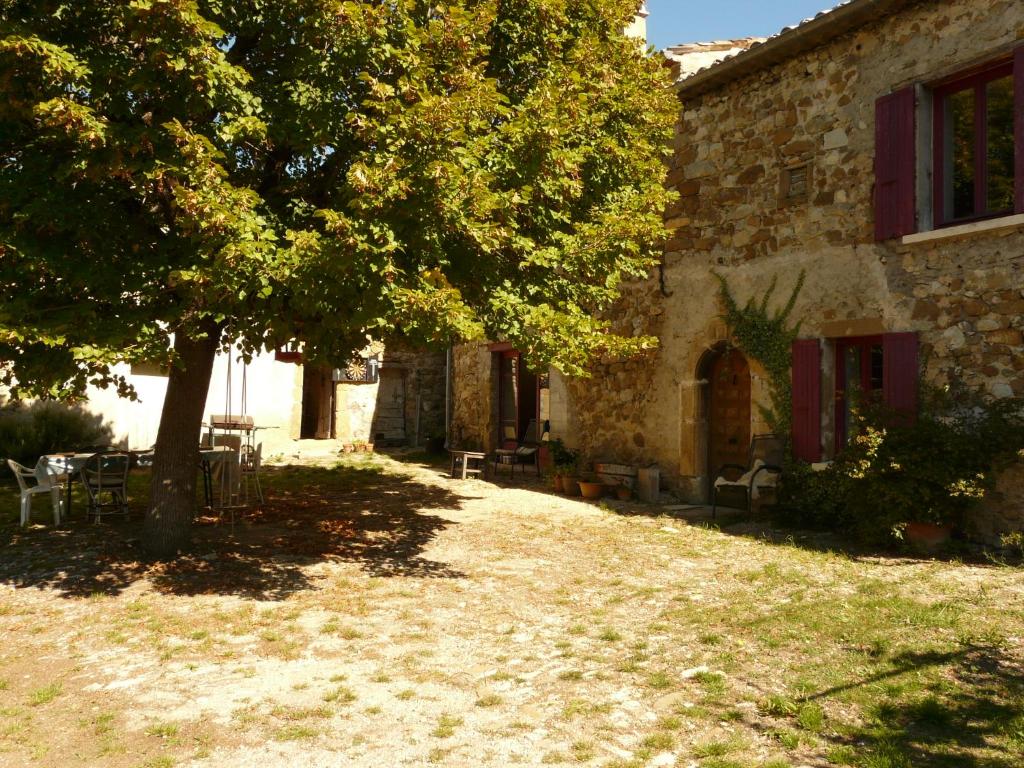 a tree in front of a building with a tree at Ferme de la Rose in Rosans