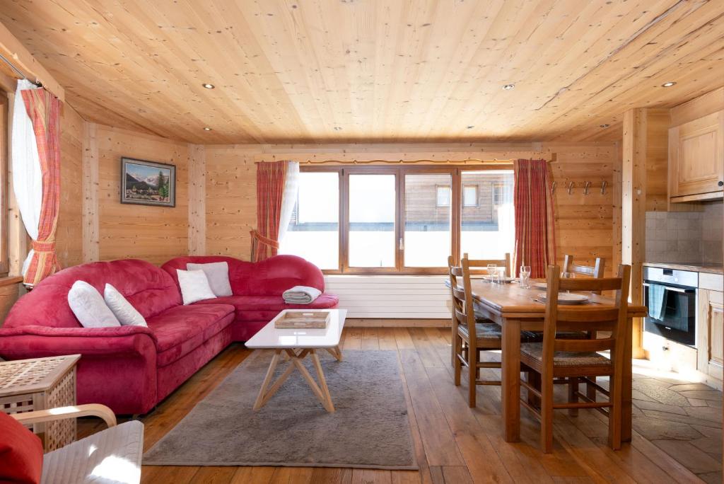 a living room with a red couch and a table at Claire Joie in Verbier