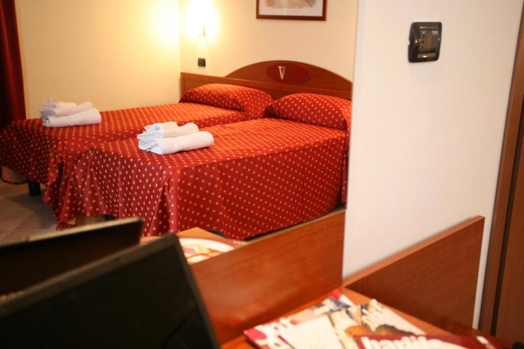 a hotel room with two beds and a mirror at Hotel Della Volta in Brescia