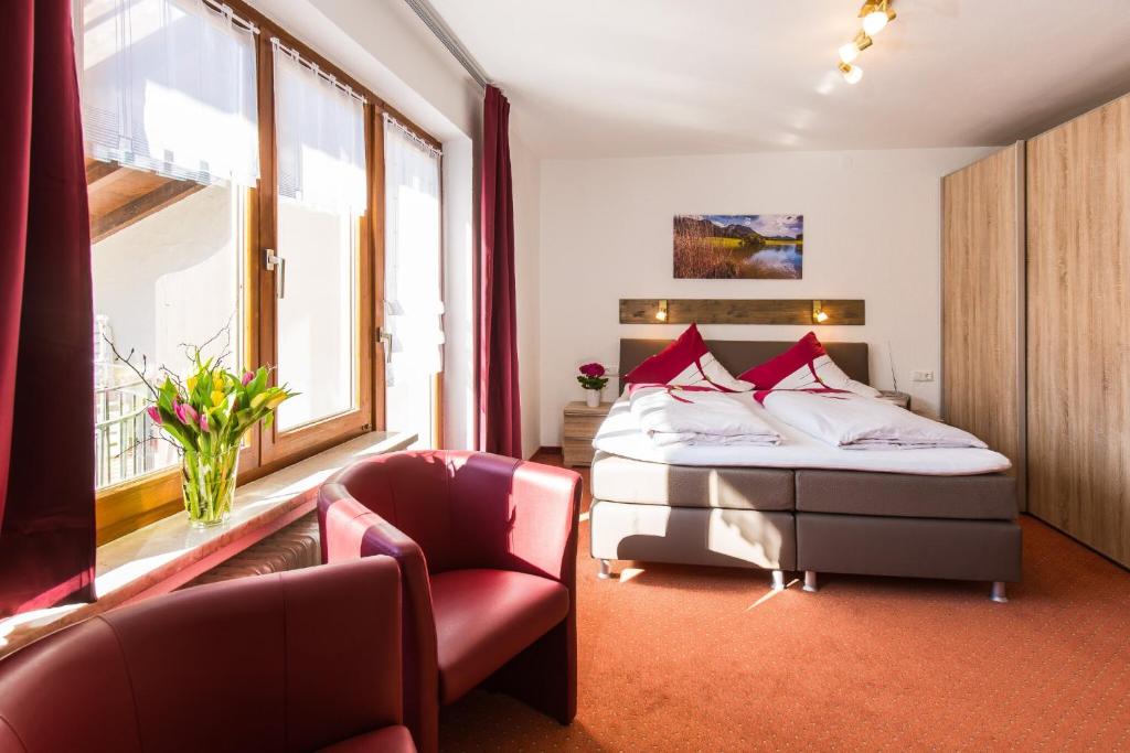 un dormitorio con una cama y una silla en Gästehaus Wolfgang Mittersee -4-, en Ruhpolding