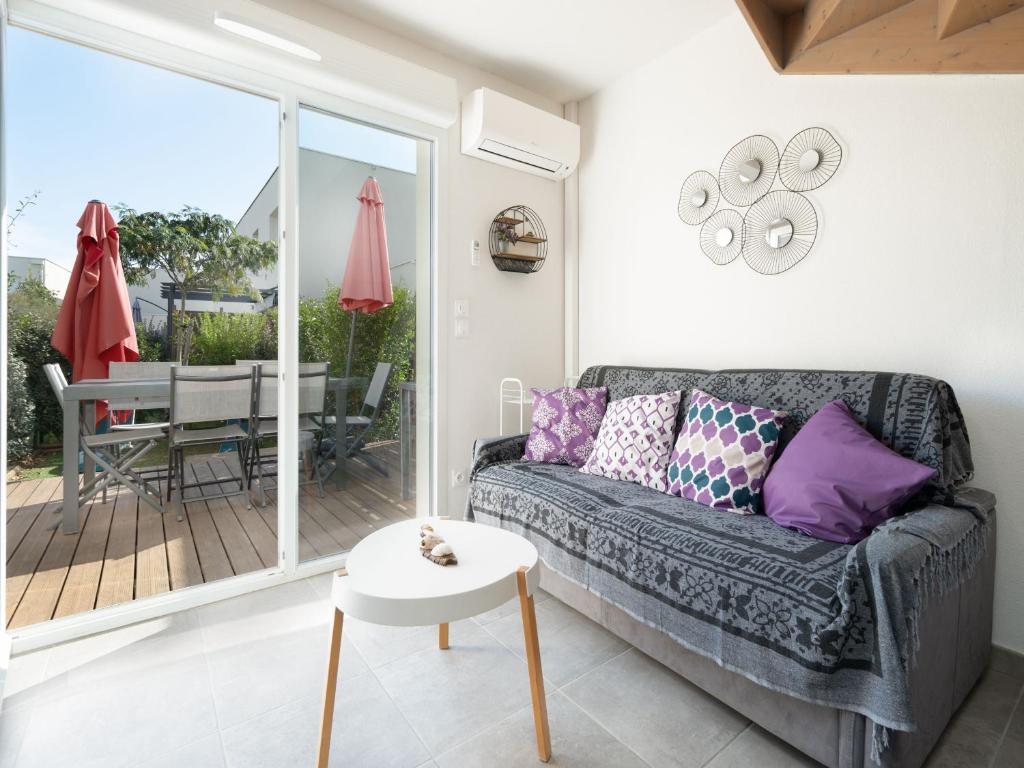 un salon avec un canapé et une table dans l'établissement La Dune 67 - Villa 3P6, à Sérignan