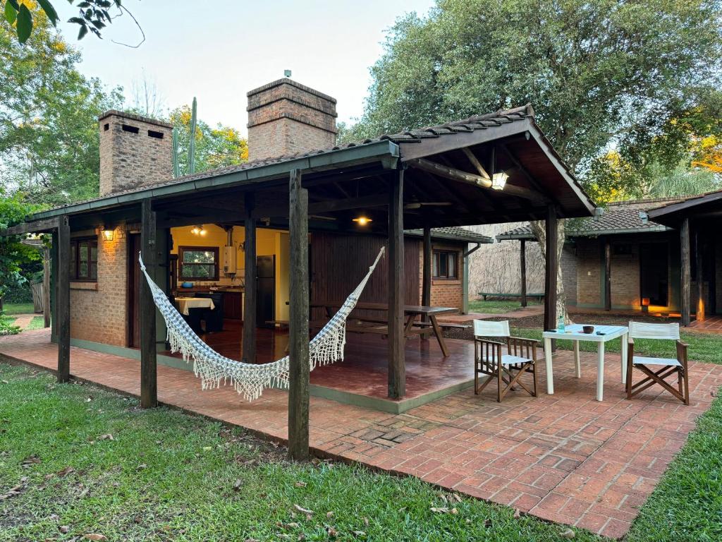 un pabellón con hamacas en un patio de ladrillo en Cabañas lodge El Suizo, en Gobernador Virasora