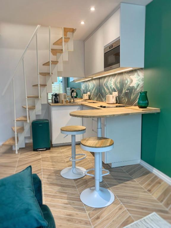 une cuisine avec un comptoir et des tabourets dans une pièce dans l'établissement Tiny house avec terrasse privée, à Mulhouse