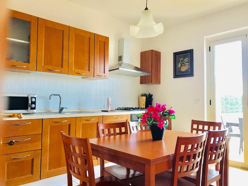a kitchen with a wooden table and wooden cabinets at Isca Calabretta Apartments M28 in Isca sullo Ionio