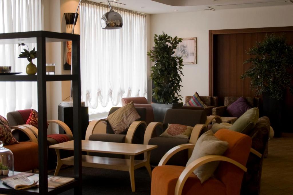 a living room filled with couches and a table at Hotel Datini in Prato