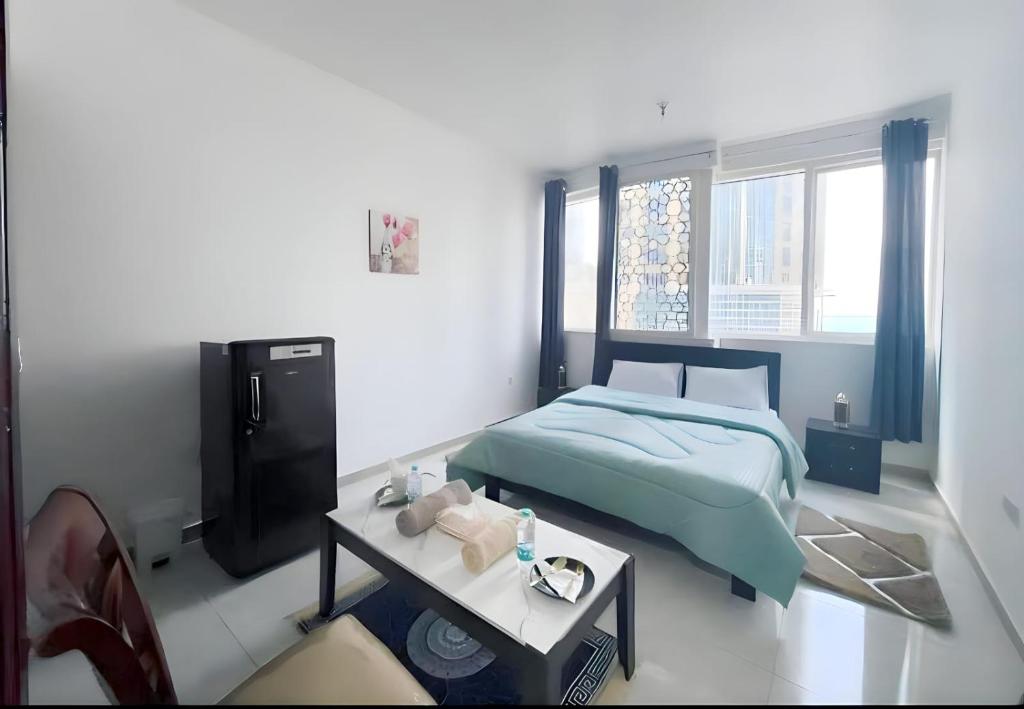 una camera da letto con un letto, una tv e un tavolo di Suave Sea View Stay Abu Dhabi a Abu Dhabi