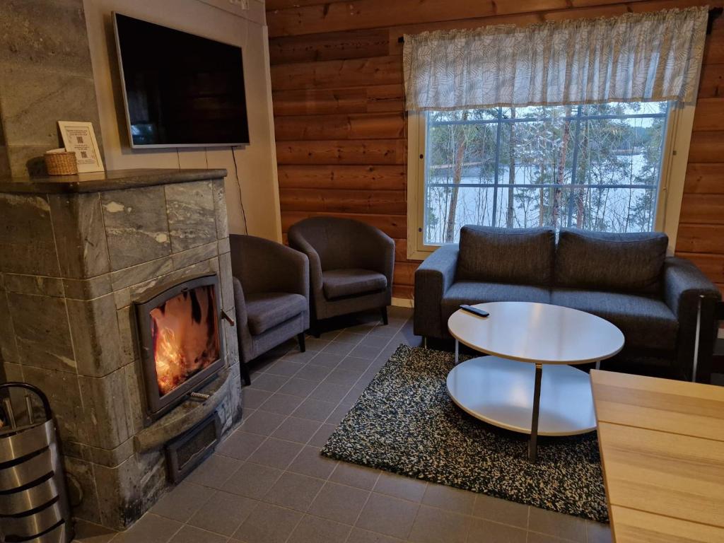 a living room with a couch and a fireplace at Rauhalahti Holiday Homes in Kuopio