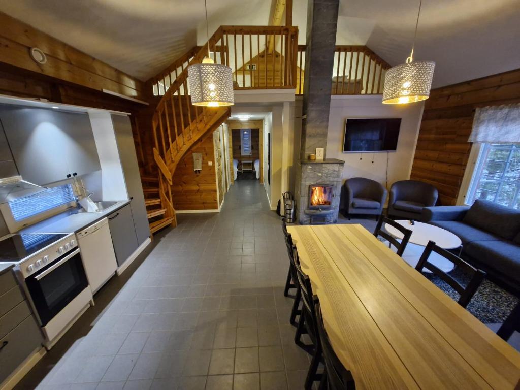 a kitchen and a living room with a wooden table at Rauhalahti Holiday Homes in Kuopio