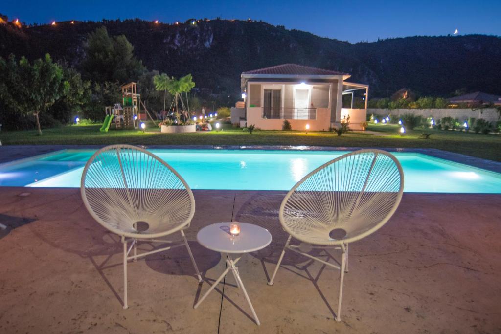 dos sillas y una mesa frente a una piscina en Casa di Varco en Lefkada