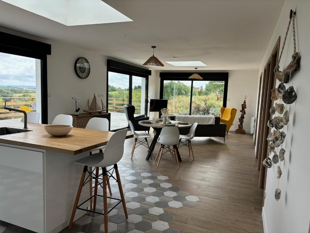 eine Küche und ein Wohnzimmer mit Tisch und Stühlen in der Unterkunft La Vallée des Biches G1 in Saint-Martin-Boulogne