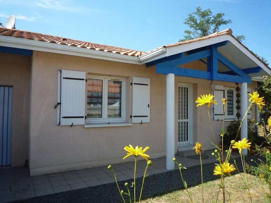 une petite maison avec deux fenêtres et des fleurs jaunes dans l'établissement Bassin d'Arcachon Maison au calme, à Gujan-Mestras
