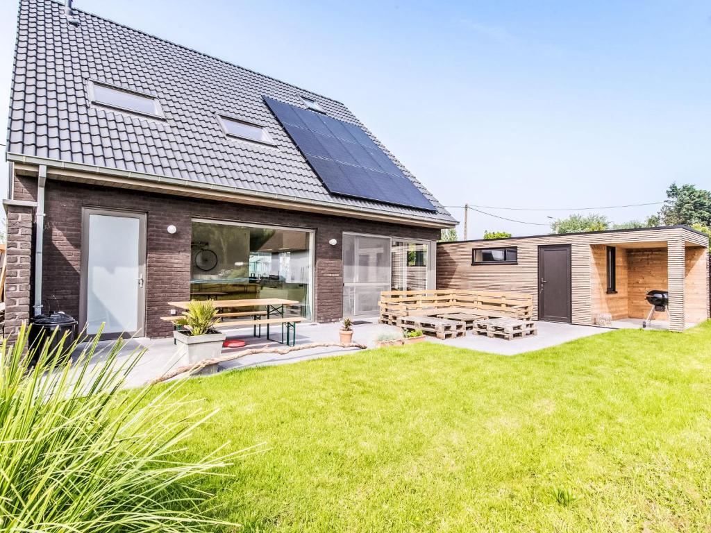 a house with solar panels on the roof at Villa Villa Vosseslag - garage and big garden by Interhome in De Haan
