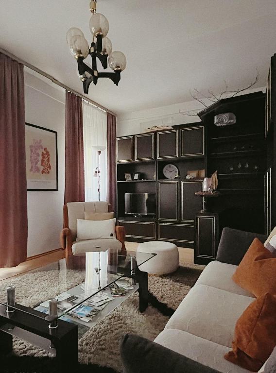 a living room with a couch and a glass table at AJ - tér apartman miskolc in Miskolc