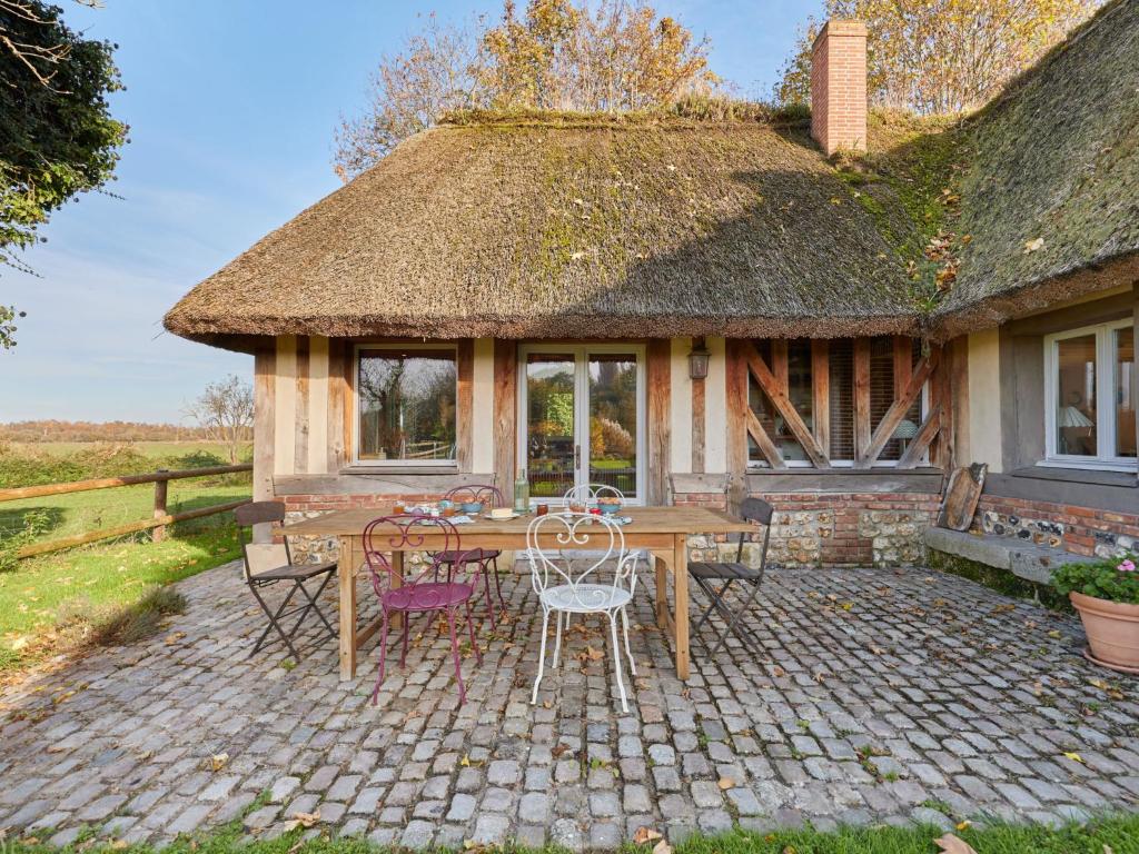 un patio con tavolo e sedie di fronte a una casa di Holiday Home 2 Chaumières normande by Interhome a Le Perrey