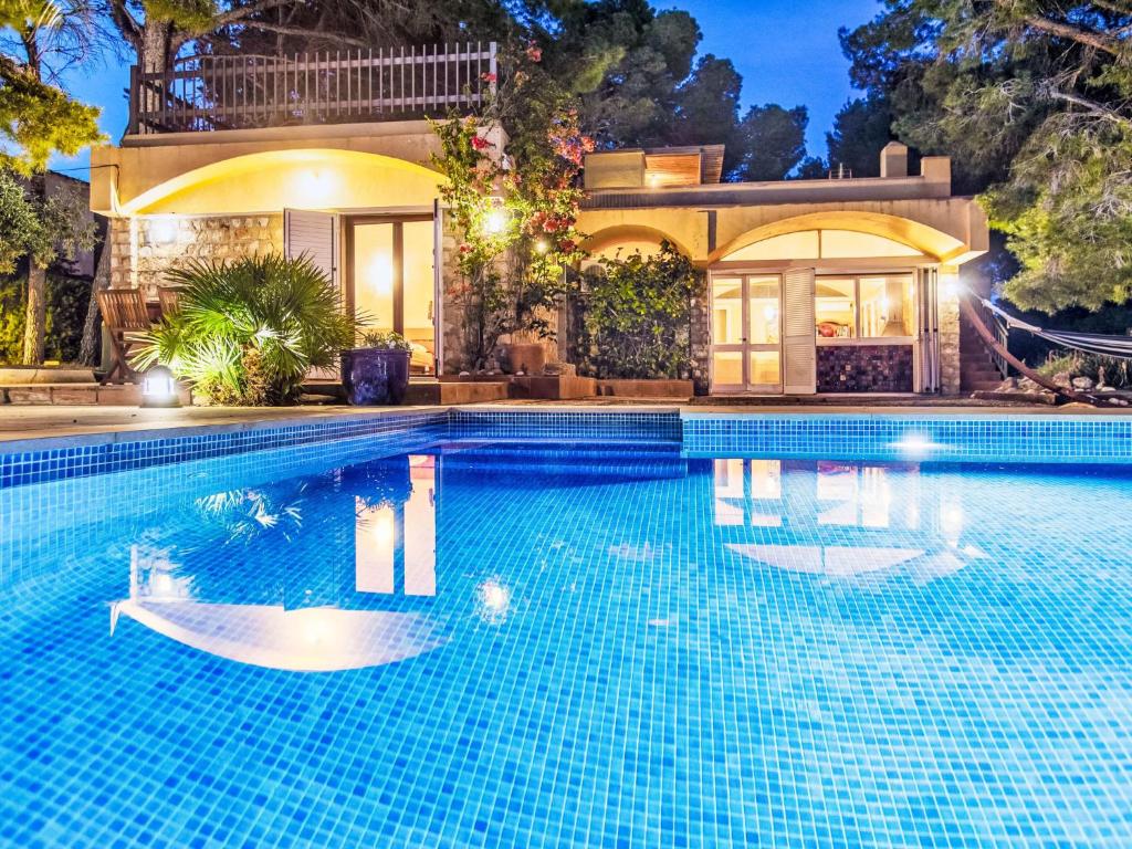a swimming pool in front of a house at Villa Platja Calafato by Interhome in L'Ametlla de Mar