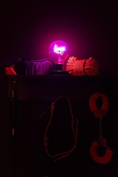 a dark room with a pink lamp on a table at Nuit D'or - Royale Room in Épernay