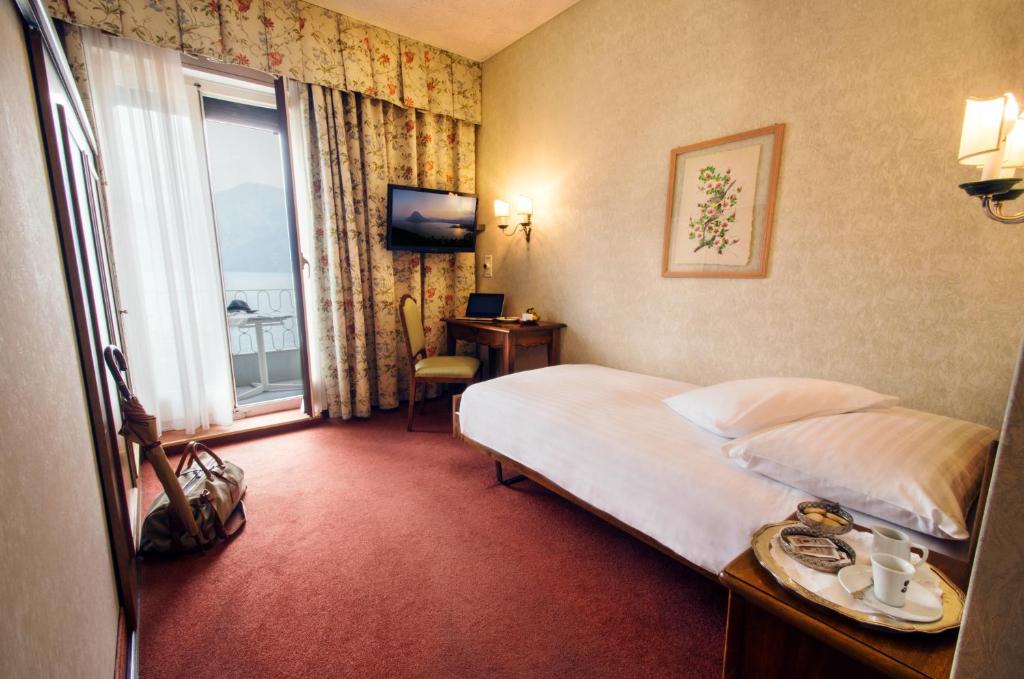 Postel nebo postele na pokoji v ubytování International au Lac Historic Lakeside Hotel