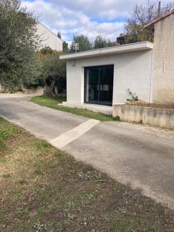 une route vide devant un bâtiment blanc dans l'établissement Studio neuf a la campagne a 10 minutes des plages de mediterranée, à La Bouilladisse
