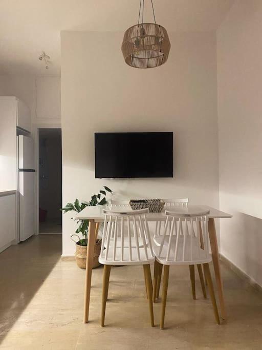 a dining room with a table and two white chairs at Central in Argostoli