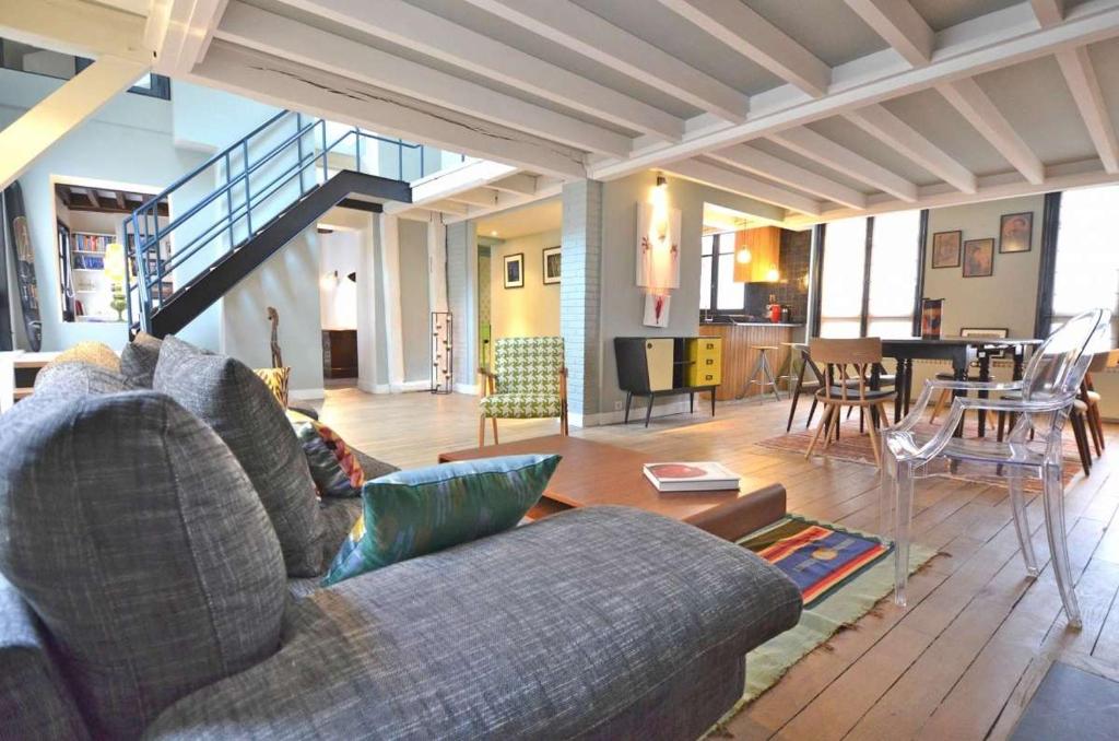 un salon avec un canapé et une salle à manger dans l'établissement Grande Pomme, à Paris