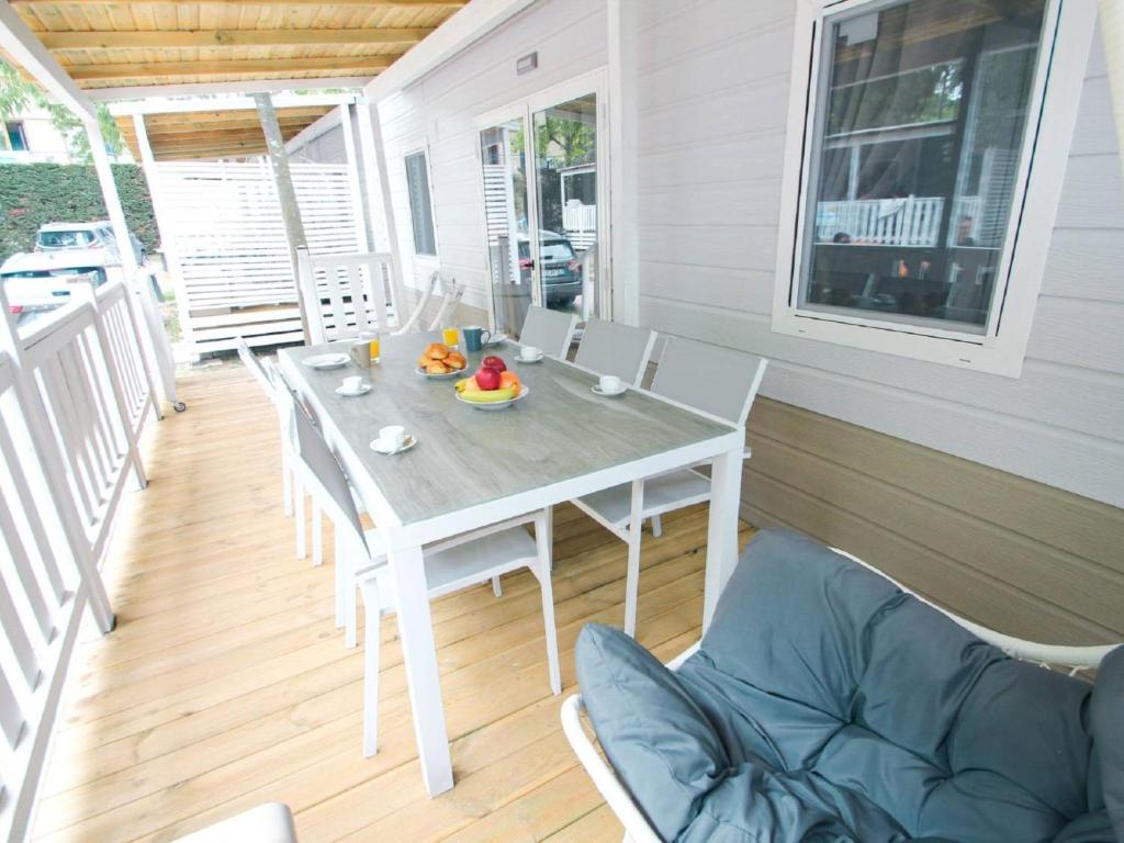 a white table and chairs on a porch at Holiday Home Happy Superior by Interhome in Marina di Bibbona