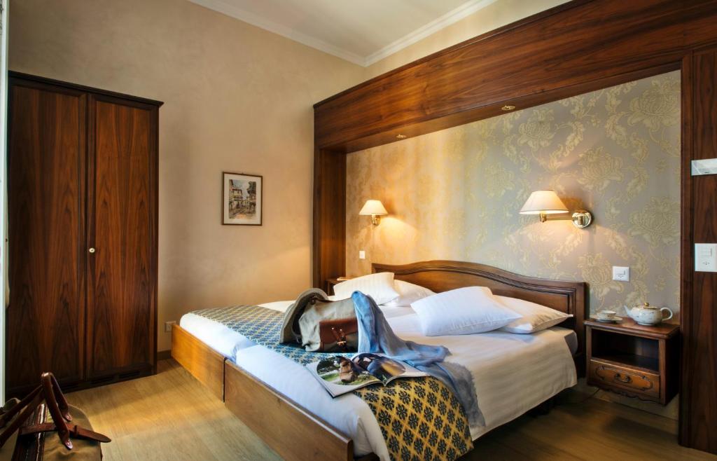 Postel nebo postele na pokoji v ubytování International au Lac Historic Lakeside Hotel
