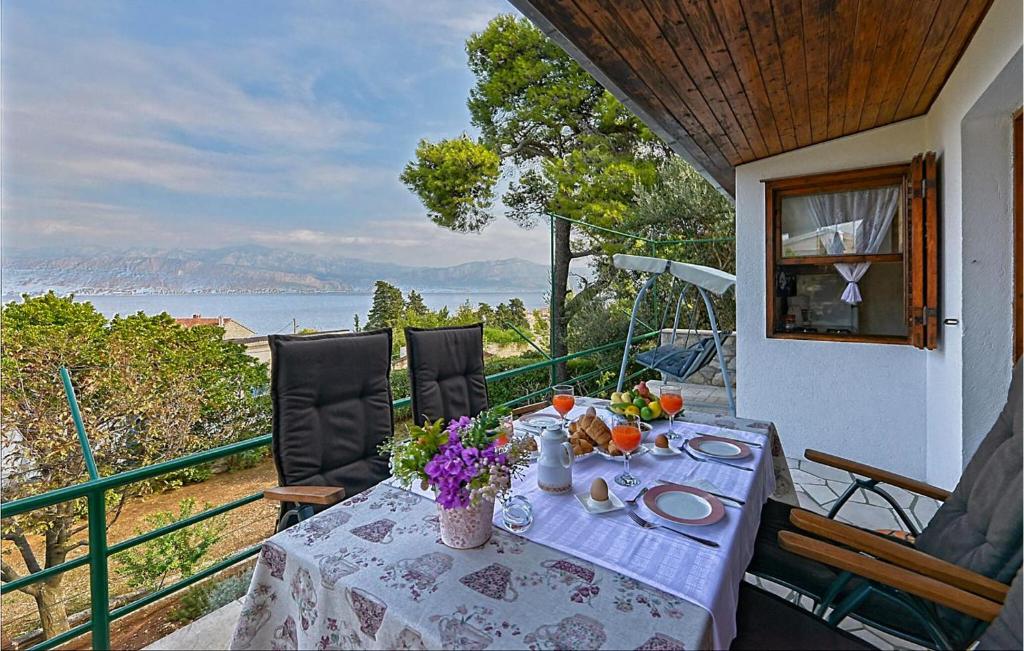 a table on a balcony with a view of the water at 2 Bedroom Lovely Home In Brac in Postira