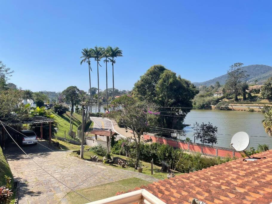 a view of a river with palm trees and a house at Mirante do Lago - Suíte Gold em frente ao Lago de Javary in Miguel Pereira