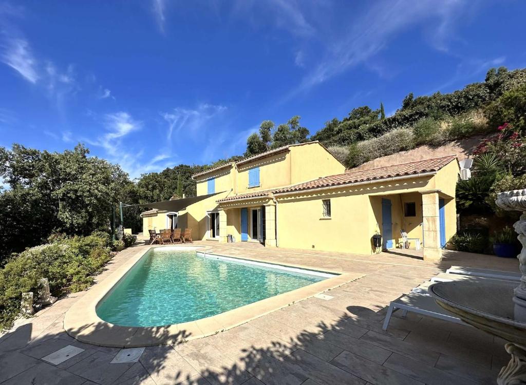une piscine devant une maison dans l'établissement Villa Myosotis pour 8 personnes avec piscine chauffée et vue mer à La Londe-Les-Maures, à La Londe-les-Maures