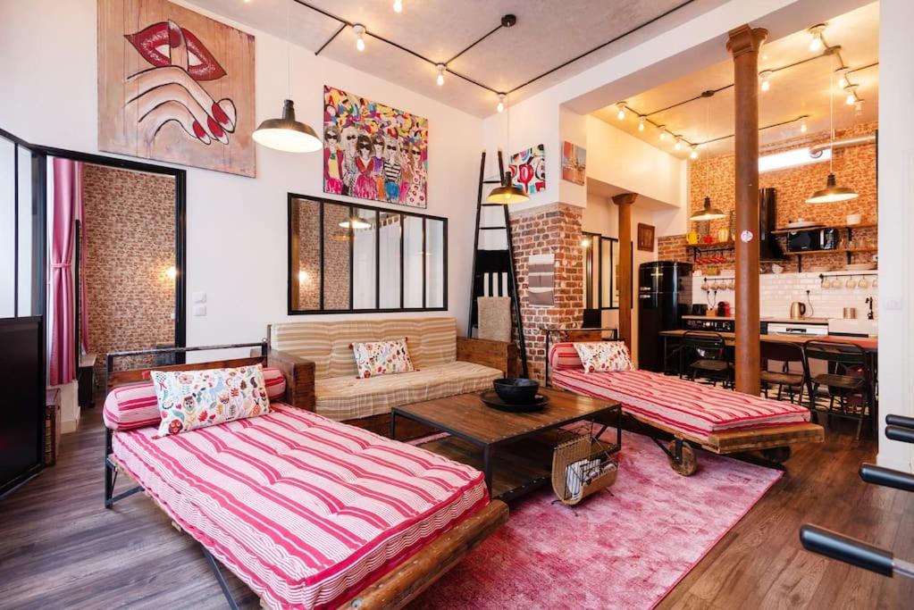 un salon avec deux canapés et une table dans l'établissement Montmartre Rue des Martyrs Loft with AC, 4-7 PEO, à Paris