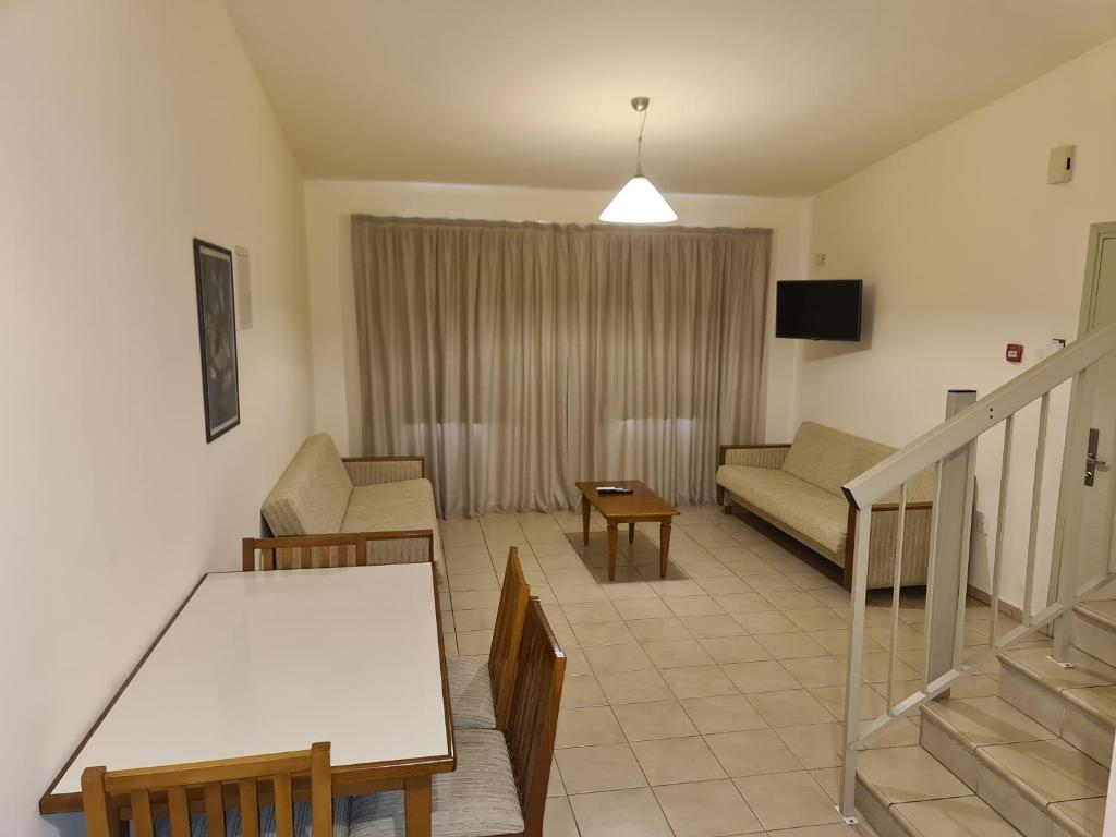 a living room with a couch and a table at Nissiana Hotel & Bungalows in Ayia Napa