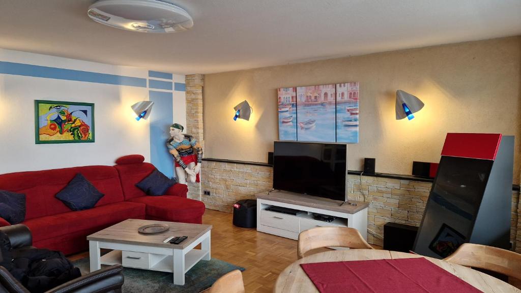 a living room with a red couch and a flat screen tv at Ferienwohnung Bad Neuenahr in Bad Neuenahr-Ahrweiler