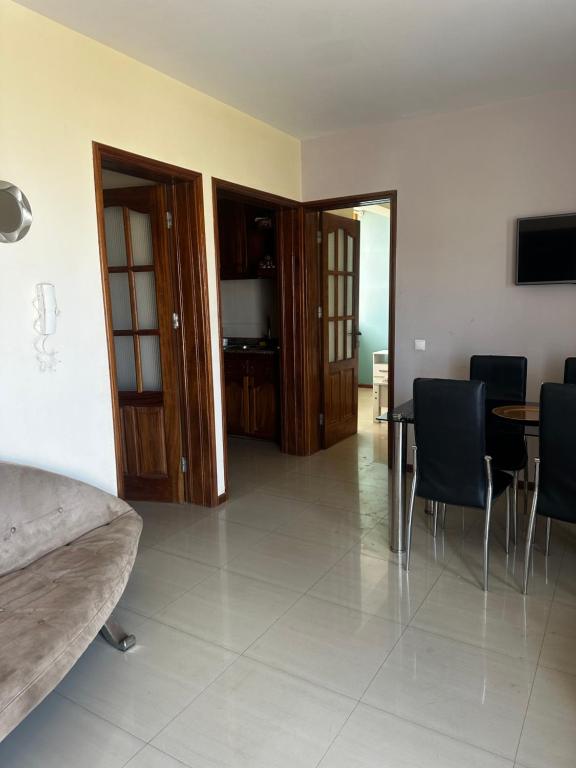 a room with a table and chairs and a bedroom at T2 Alto Miradouro in Mindelo